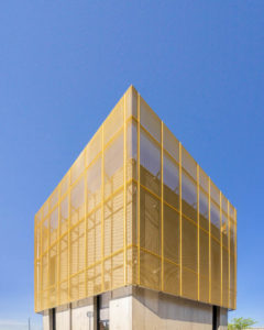 Vue de profil du la Maison de la Mobilité, conçue en béton recouvert de maille dorée par les architectes Esteves & Dutriez