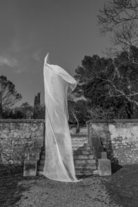 Grand drapé de tissus blanc au pied des marches, dans les jardins de la fontaine de Nîmes