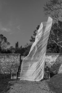Grand drapé de tissus blanc au pied des marches, dans les jardins de la fontaine de Nîmes