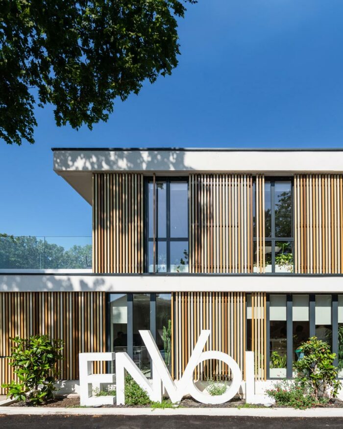 Image d'un détail de la façade du siège social de la société Envol à Montpellier, France. Le bâtiment est en verre et béton. Il est composé de plusieurs étages. Le logo de la société Envol est visible sur la façade. L'image a été prise par Ludovic Maillard, photographe d'architecture.