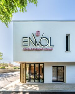 Image de la façade du siège social de la société Envol à Montpellier, France. Le bâtiment est en verre et béton. Il est composé de plusieurs étages. Le logo de la société Envol est visible sur la façade. L'image a été prise par Ludovic Maillard, photographe d'architecture.